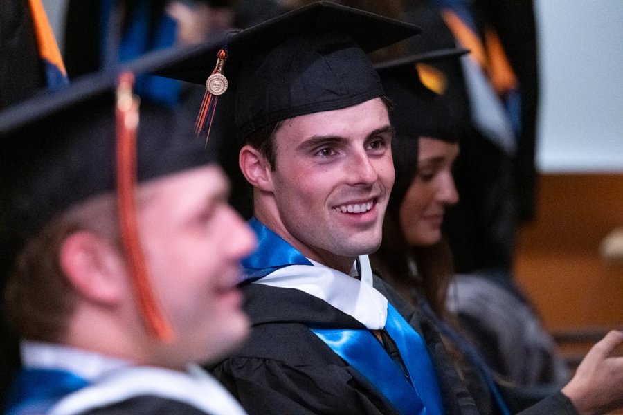 Graduate Charlie Crean sits in the Ballroom during Special Commencement.
