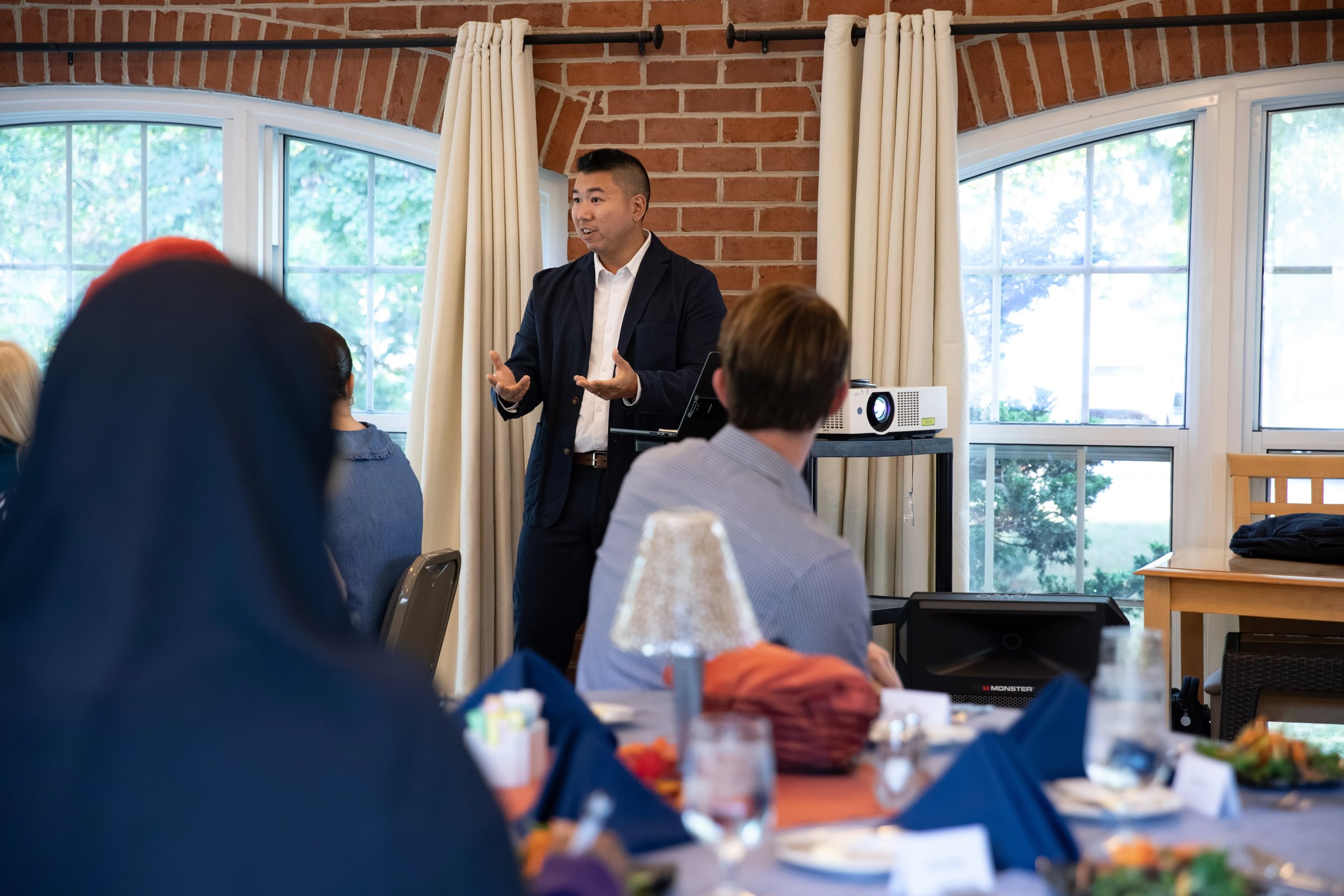 A man speaking at a dinner event