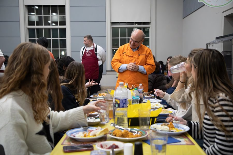 President Bob Iuliano taling with students at the caf