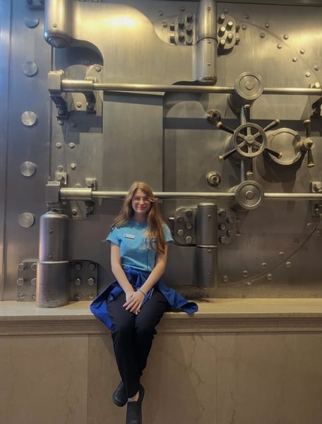 Colleen Bergmann &rsquo;25 standing in front of a bank vault at the Milken Center in Washington, D.C.