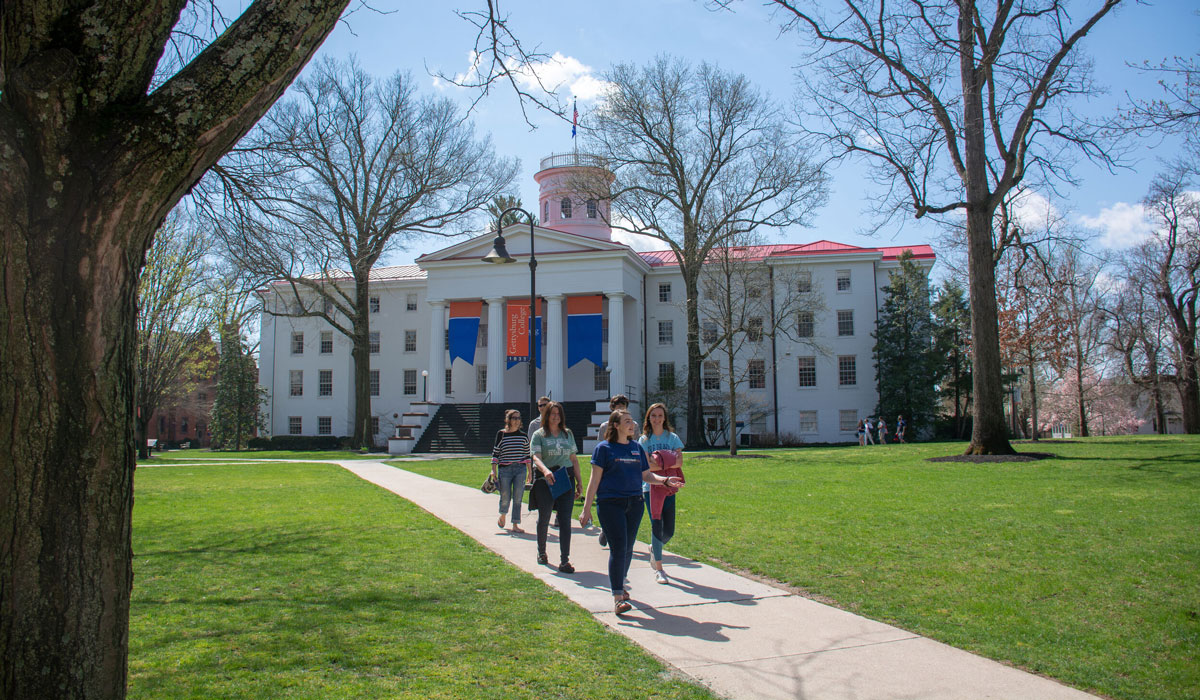 Admissions tour guide leading group of people past Penn Hall