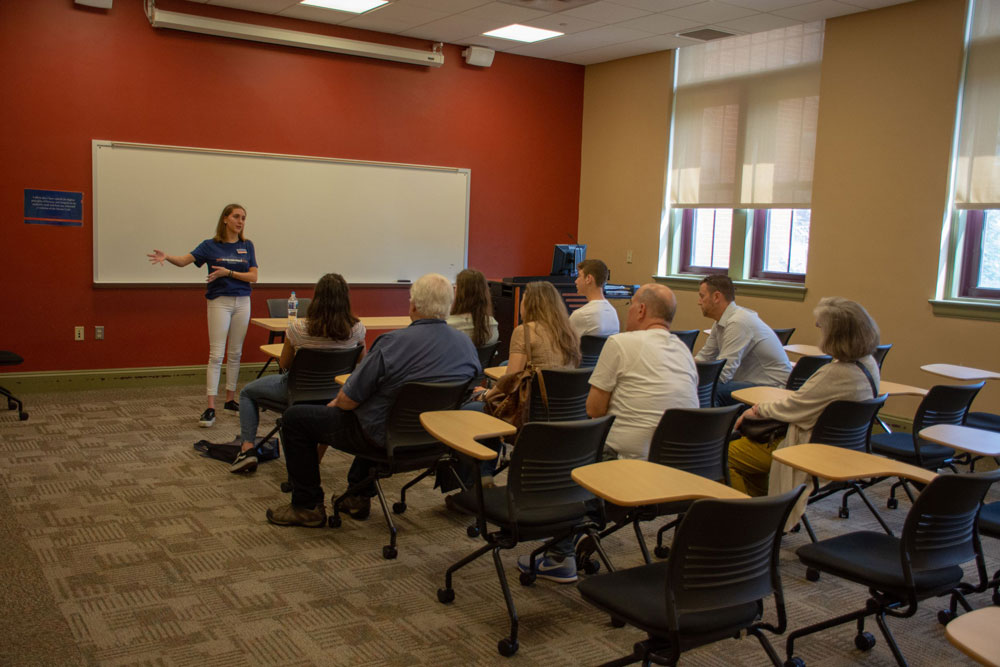 Tour guide speaking with a tour group in a classroom