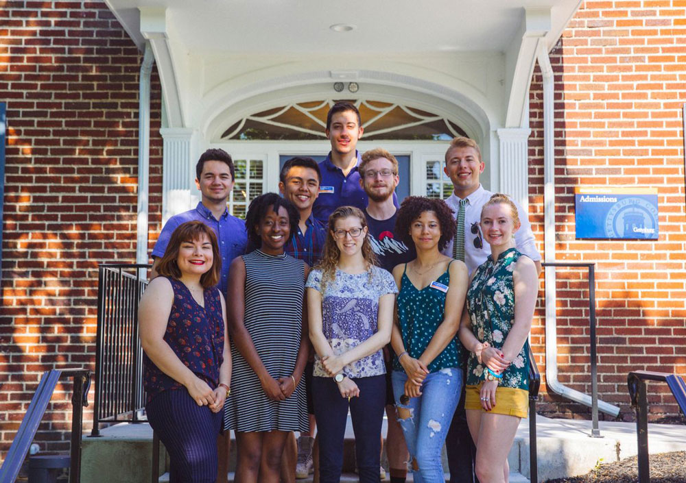 Admissions tour guides posing together in front of the Admissions building