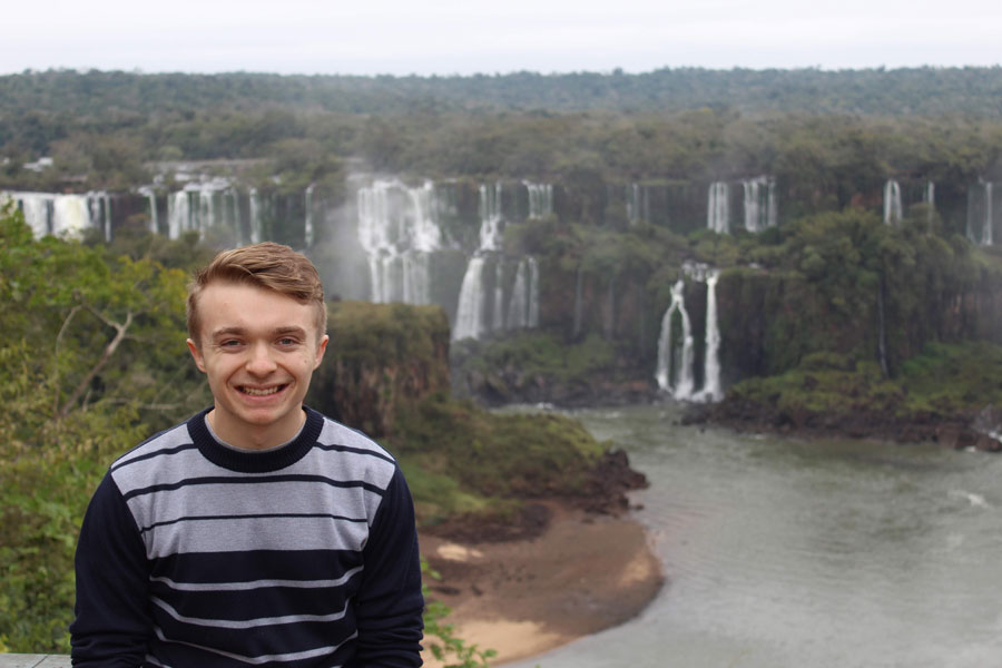 Anthony Wagner standing in front of a waterfall on the border of Argentina and Brazil