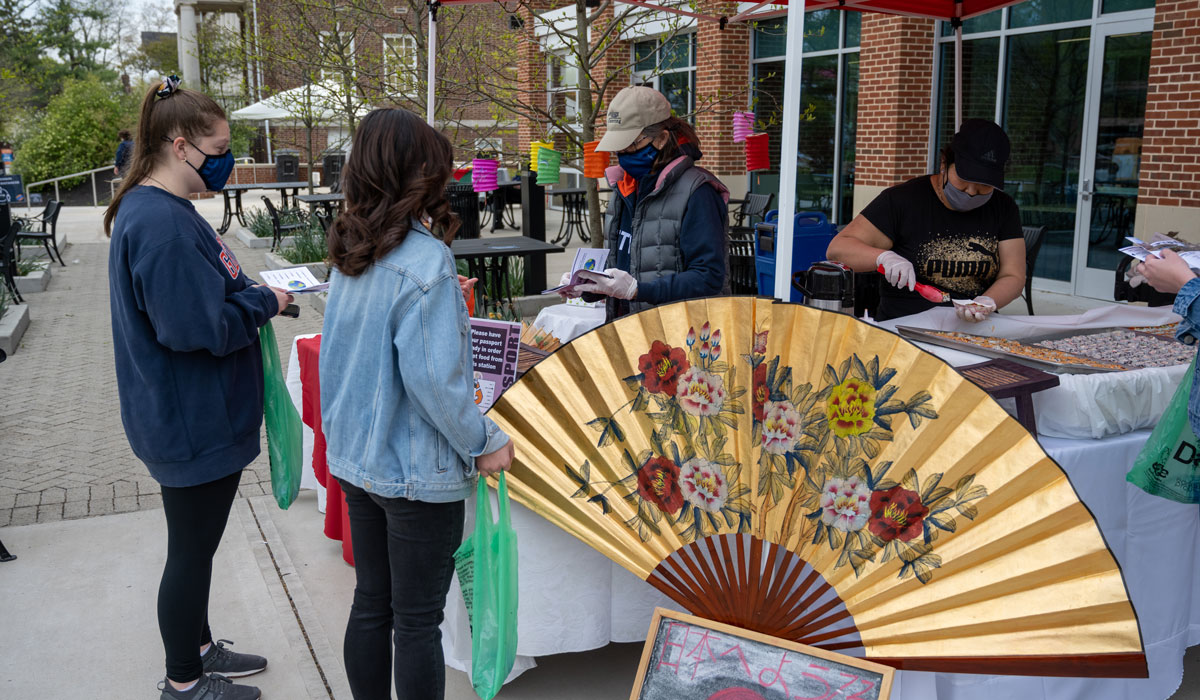 Students getting food from an asian food stand