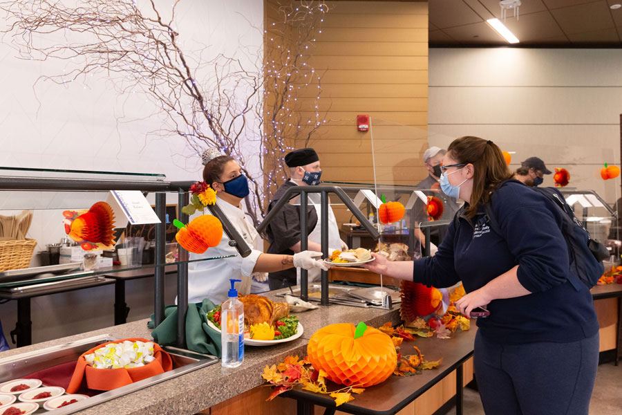 Student receiving food from Servo's thanksgiving buffet