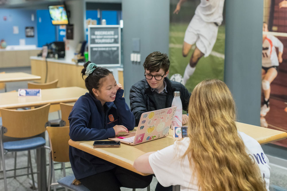 Students sitting at a table during a recreational event