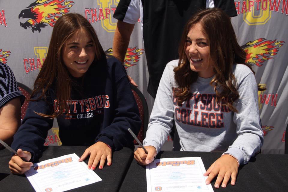 Taylor and Madison signing acceptance letters to play for the Bullets softball team