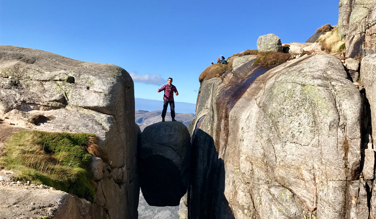 Colin Hetherington standing on a boulder wedged between to cliffsides