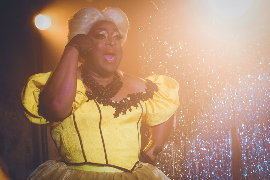 Darryl Jones performing in Drag with a yellow dress and a blonde wig