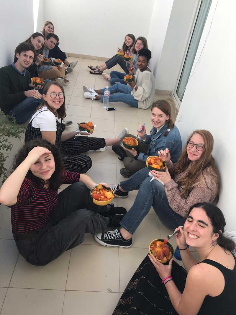 Students eating soup on the floor together
