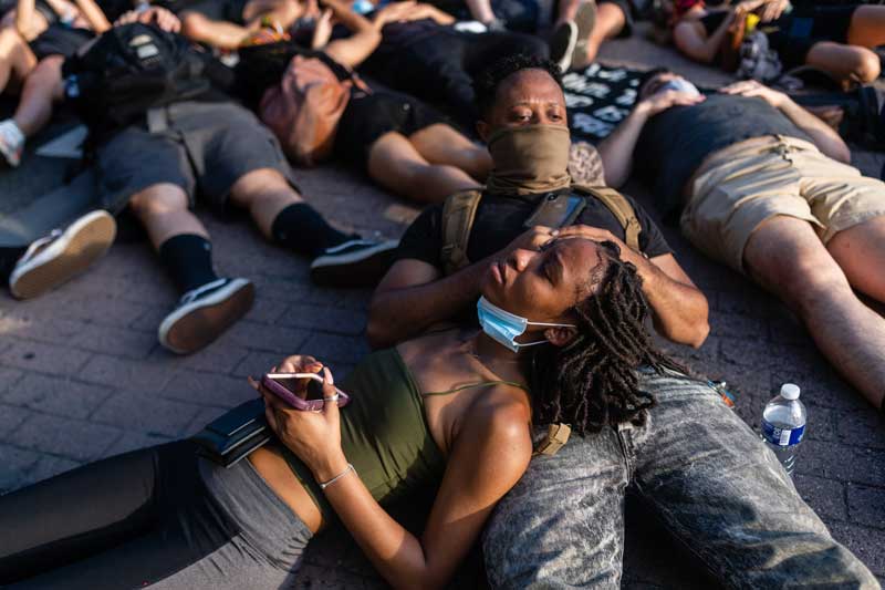 One female demonstrator lying on another male demonstrator during a demonstration against police brutality