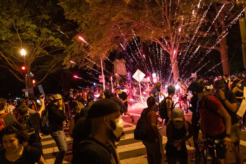 Protestors fleeing a firework explosion in the street in Washington DC