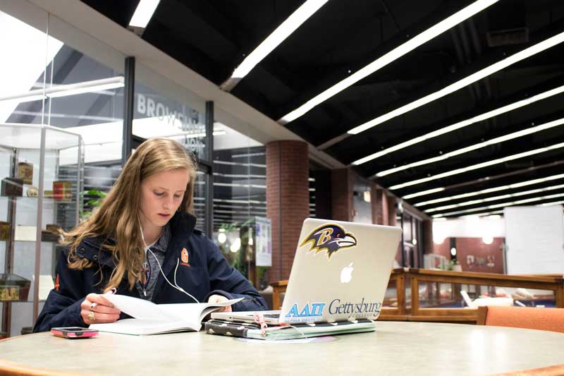 Female student studying with her laptop in the library