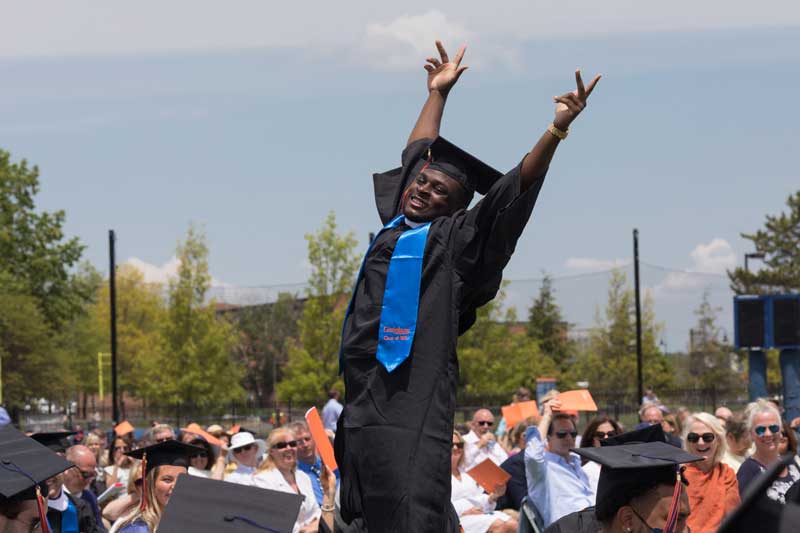 Student standing up with his hands in the air