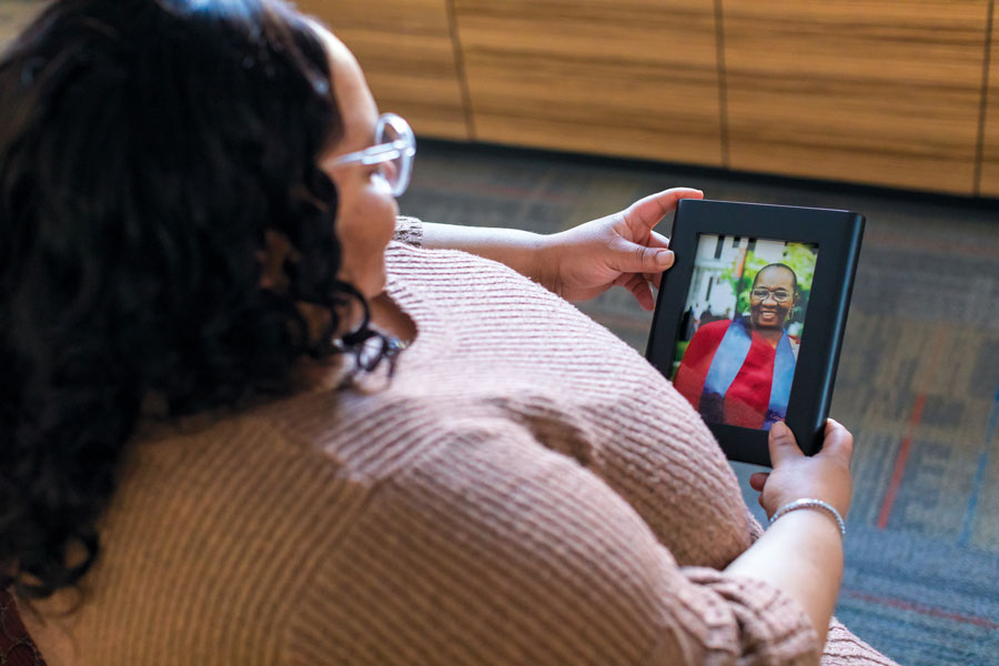 Monique Gore holding a picture of her grandmother with a stole of gratitude