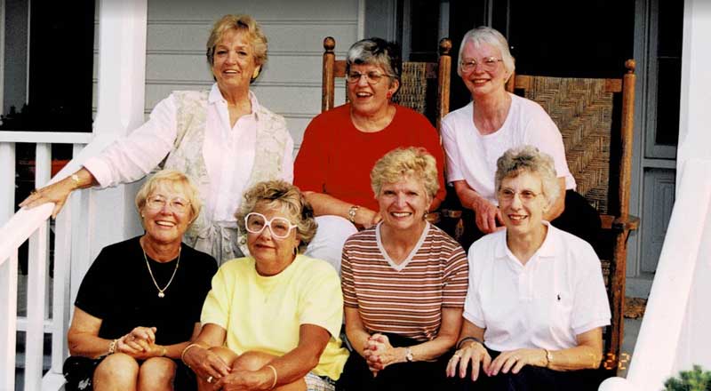 Group of female friends sitting on a porch together