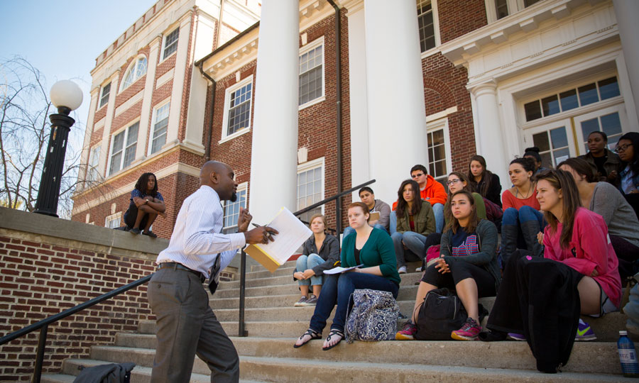 Hakim Williams with students sitting on steps