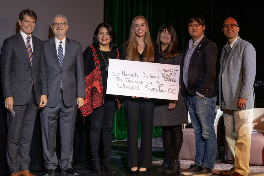 Hannah Dallman holding a very large check on stage