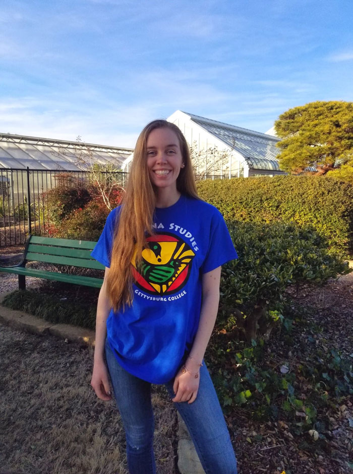 Hannah Dallman standing in front of trees and foliage