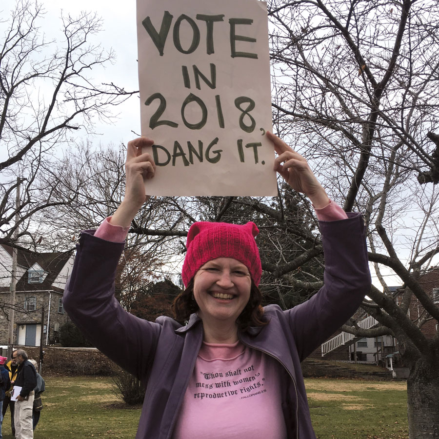 Jocelyn Swigger holding a sign that promotes voting in 2018
