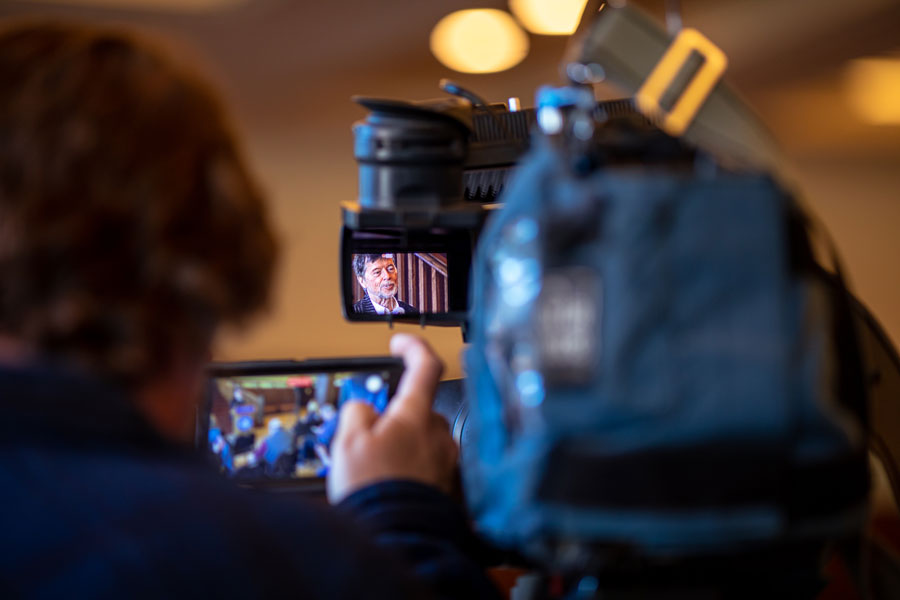 Behinds the scenes view of local media photographing Ken Burns