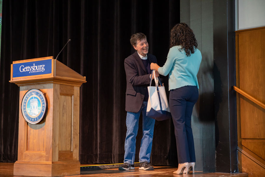 Student Senate President Miranda Zamora giving Ken Burns a gift