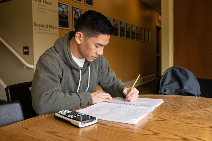 Kevin Benavente sitting with a notebook and a calculator