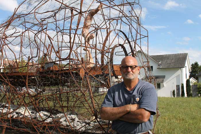 Nick Micros posing with his sculpture