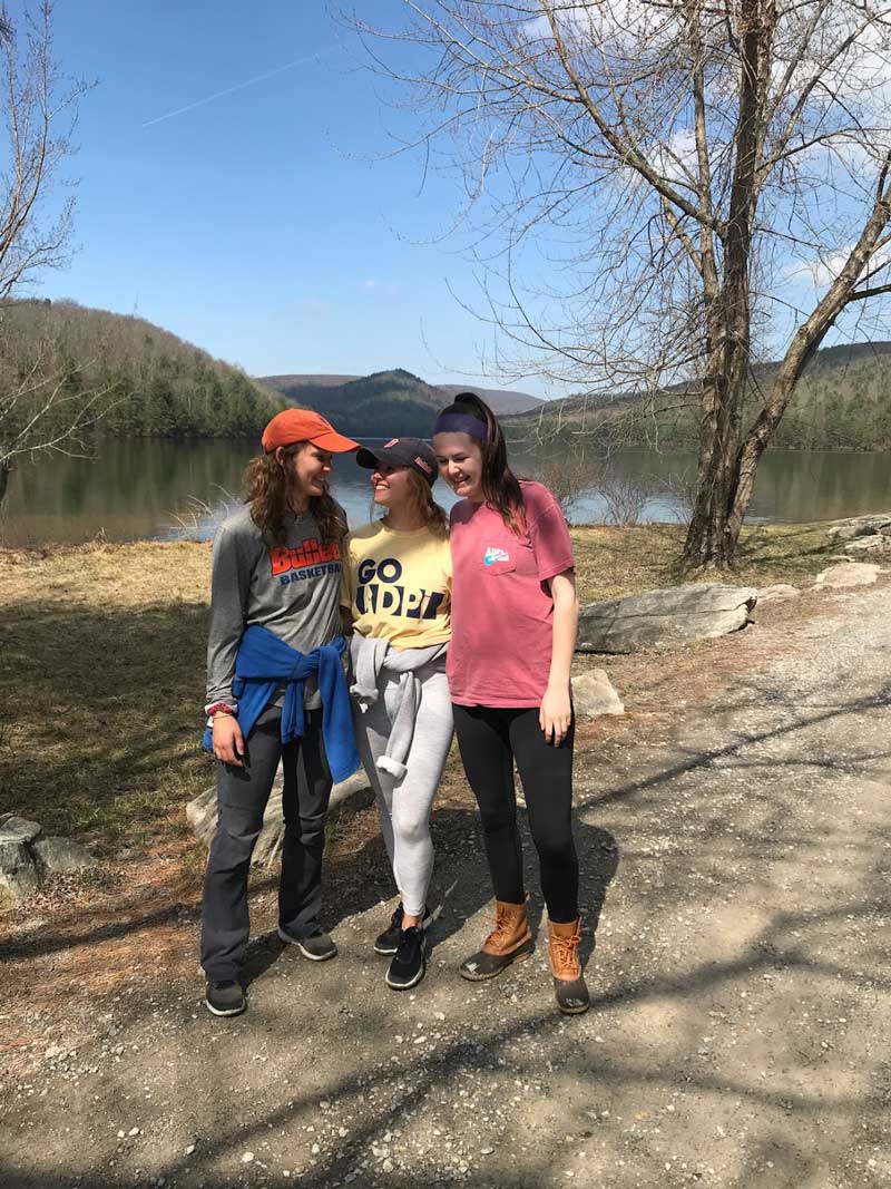 Gabi Eglinton in front of a lake with two other students