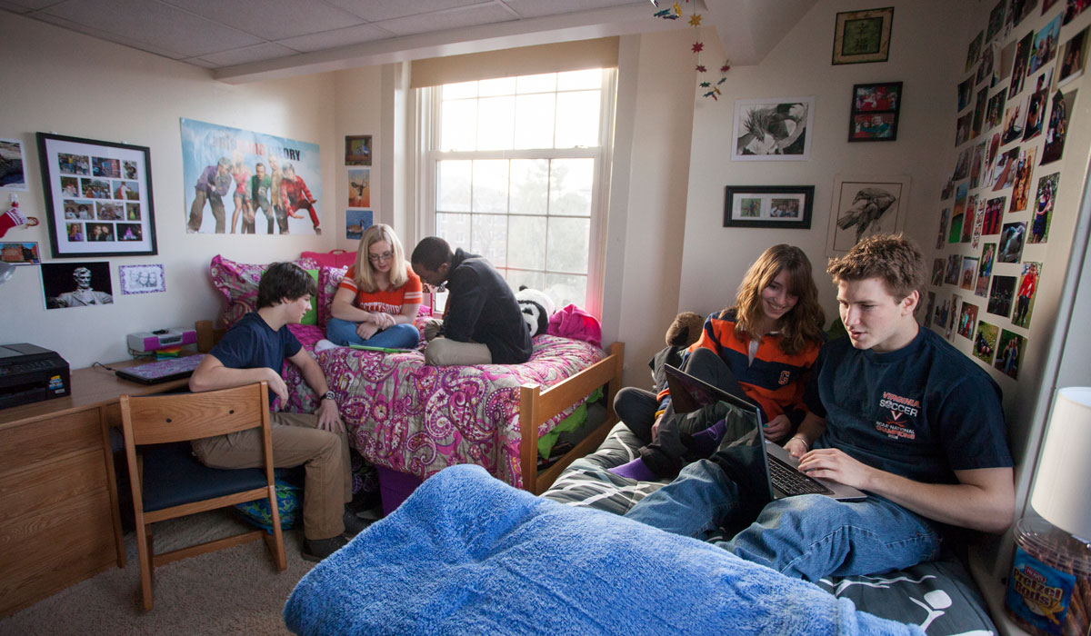 Students sitting on a bed in a dorm room