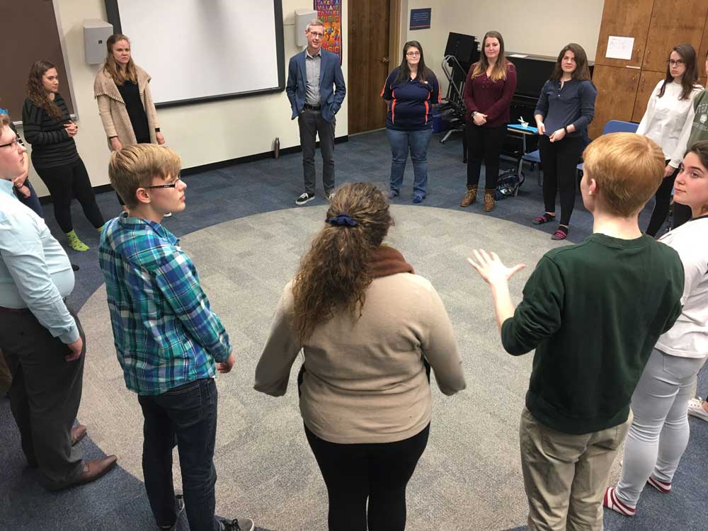 Roger Mantie speaking with students standing in a circle