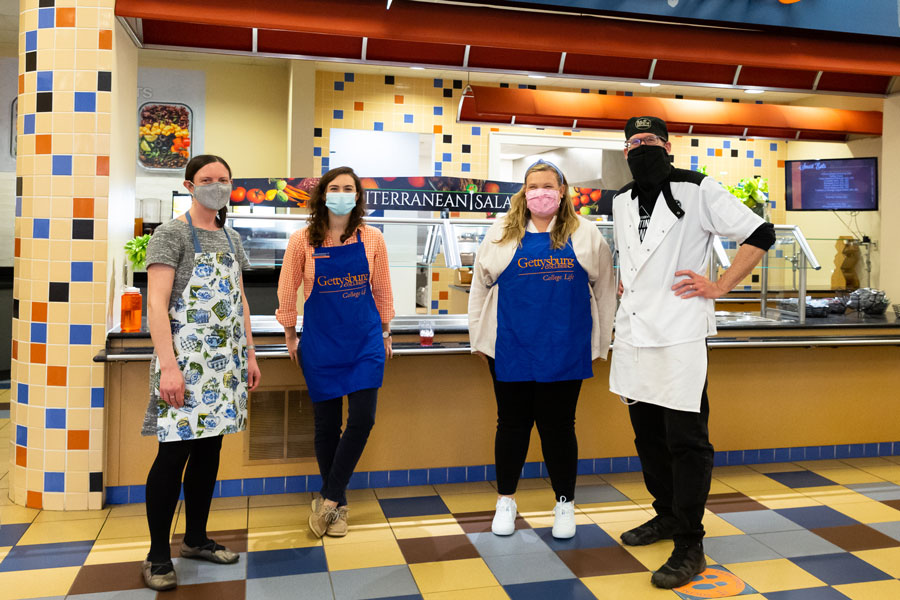 Staff volunteers wearing masks in the cafeteria