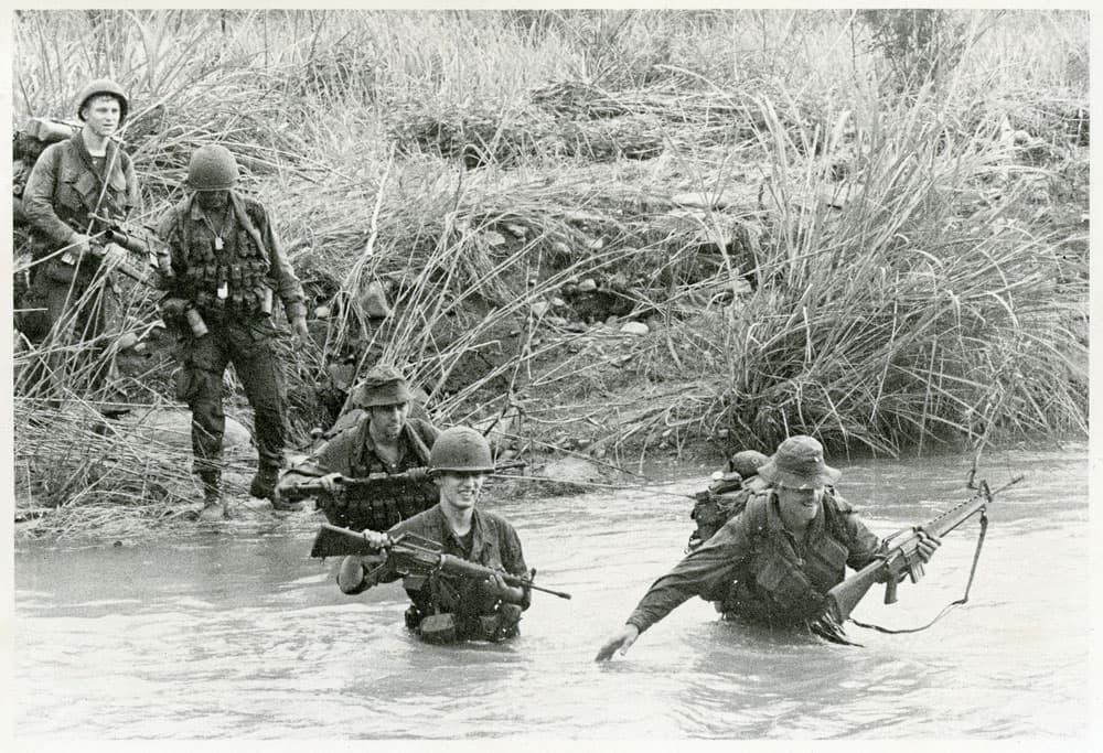 Soldiers fording through a stream in Vietnam