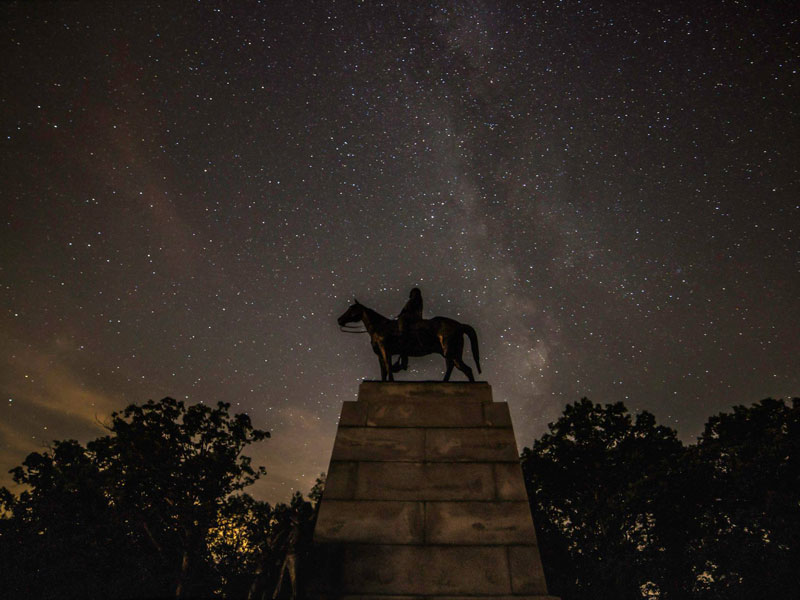 The Virginia Monument in the dark with stars overhead