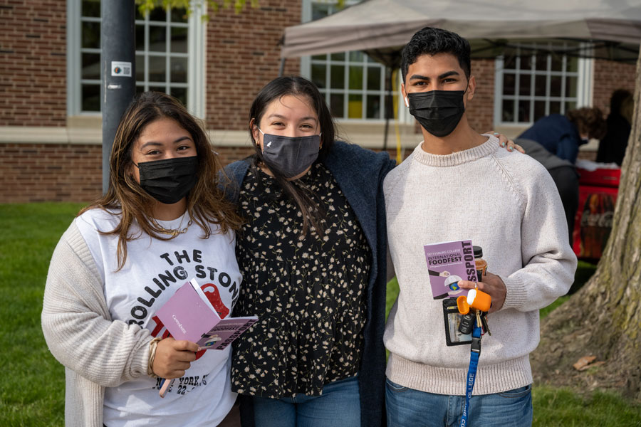 Three students holding their International Food Fest passports