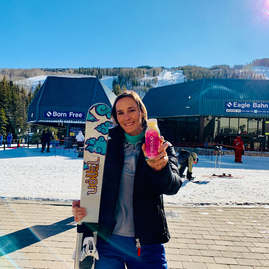 Susan Buckwalter holding a Recoup beverage and a snowboard