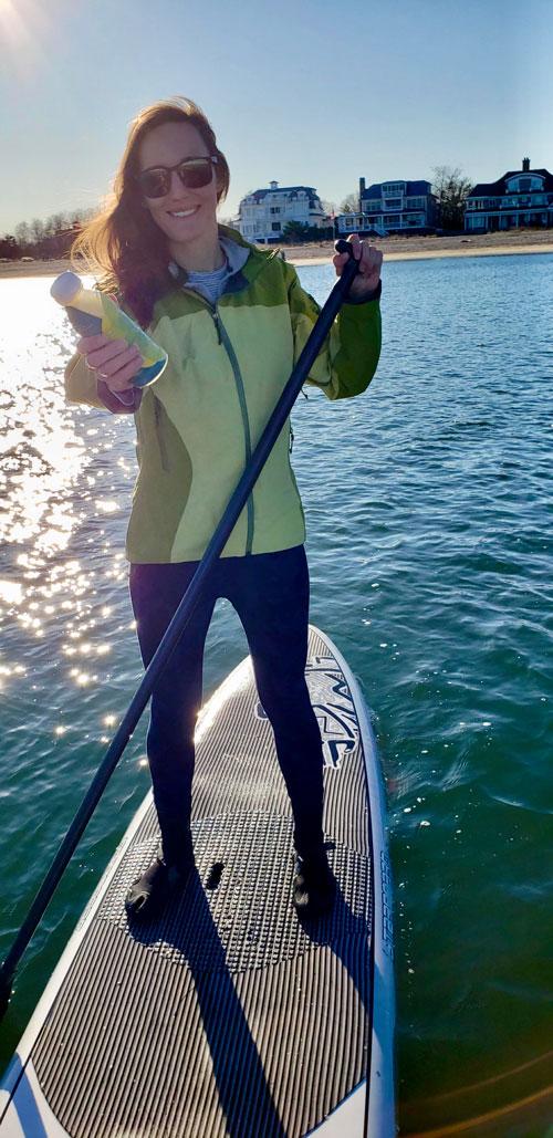 Susan Buckwalter paddle boarding with a Recoup Beverage