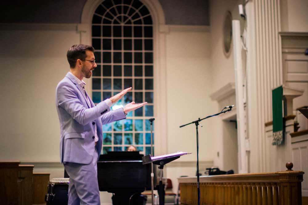 Brent Talbot directs a choir in a church
