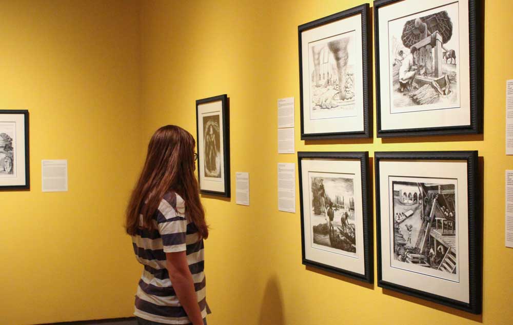 Woman in an art gallery observing artwork on the wall