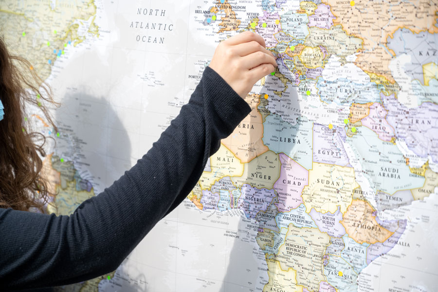 A woman putting a pin in a map of the world