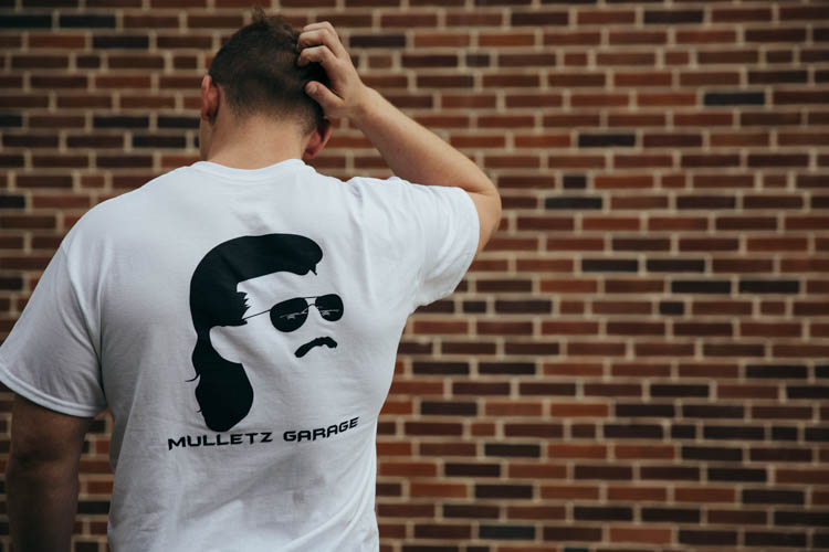 Joe Scaglione shows off the back of a promotional t-shirt for Mulletz Garage.