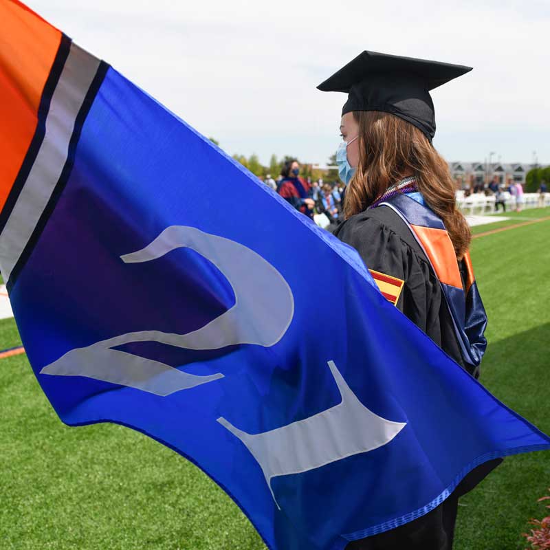 Graduate holding class of 2021 flag