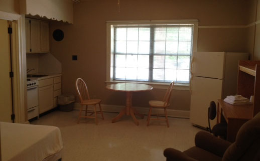 Baughman Hall kitchennette with a fridge, a table and two chairs, and a kitchennette