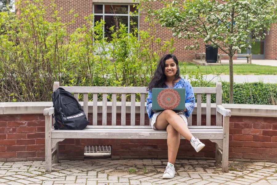 Woman sitting on a bench using her laptop