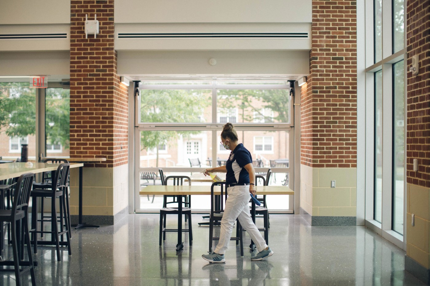 Gettysburg College staff member sanitizing tables in the CUB