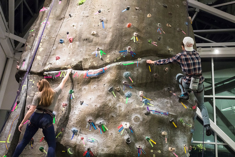 Student climbing a rock climbing wall