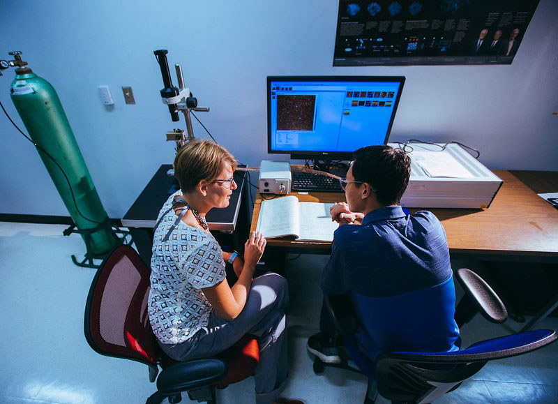 Student and teacher in a lab in front of a computer