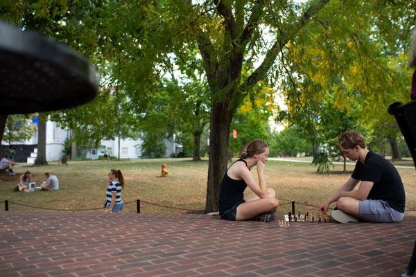 Students playing chess on library steps during Orientation