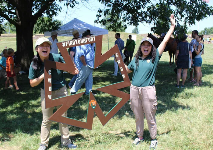 Students holding historical sign and smiling